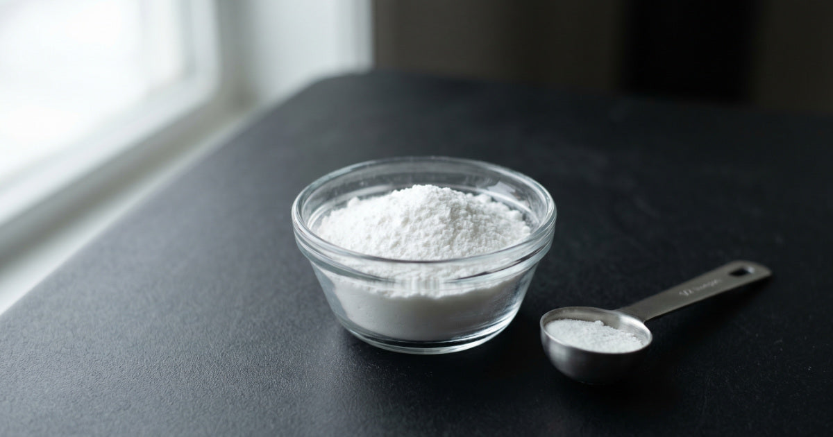 Creatine monohydrate powder with a scoop on a clean surface